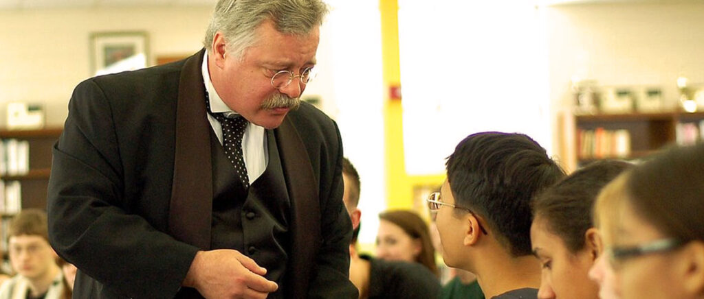 Joe, in character as Theodore Roosevelt, talking with young students